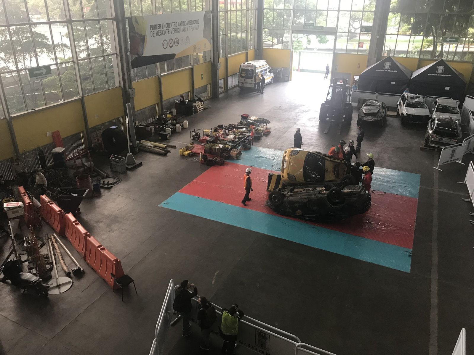 Recinto amplio con área de trabajo, herramientas y vehículos dispuestos para un desafío de rescate